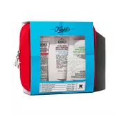 Set de regalo de viaje Kiehl's en estuche rojo. Incluye varios productos visibles a traves de una ventana con diseno en tonos azules.