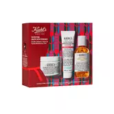 Estuche de regalo navideno "Winter Skin Soothers" de Kiehl's que incluye la crema Ultra Facial Cream, el limpiador Ultra Facial Barrier Hydrating Cleanser y el tonico Calendula Herbal-Extract Toner sobre un fondo festivo de un paisaje urbano en tonos rojo y azul.