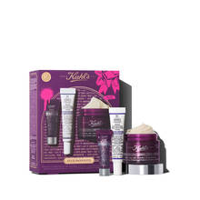 Un grafico con una caja de regalo Kiehl’s morada y detalles dorados. Contiene tres productos: "Kiehl's Super Multi-Corrective Eye Zone Treatment", "Kiehl's Retinol Skin-Renewing Daily Micro-Dose Serum" y "Kiehl's Super Multi-Corrective Cream" visible. La caja tiene salpicaduras rosas y un mono, con el texto "LET IT SMOOOOOTH".