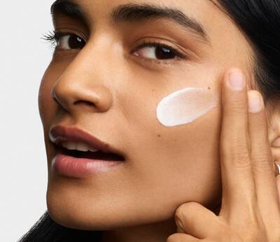 Modelo aplicando Better Screen UV Serum en su rostro