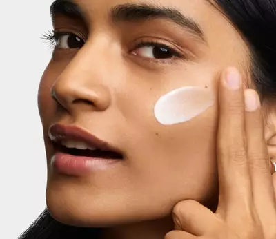 Modelo aplicando Better Screen UV Serum en su rostro
